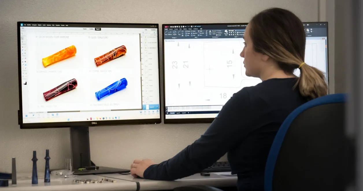 Progettista al computer con modelli 3D di componenti in metacrilato colorato